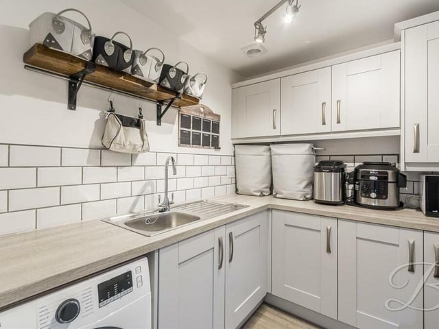 Just off the kitchen is this handy utility room, with more storage units, work surfaces, sink and space for a washing machine and tumble dryer.