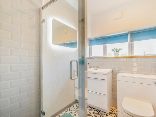 As well as the family bathroom, there is a shower room at the Mansfield property. It consists of a modern, three-piece white suite with chrome fittings. Alongside a tiled shower cubicle, there is a vanity unit with inset wash hand basin and two storage drawers beneath, and a low-flush WC. The floor is tiled.
