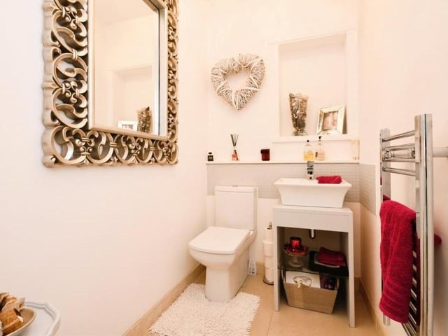 Let's move back down to the ground floor now, and before we take a look at the rest of the bedrooms, here is one of two downstairs toilets. Modern and stylish, it consists of a low-level WC, wash hand basin, heated towel-rail, porcelain tiled floor and underfloor heating.