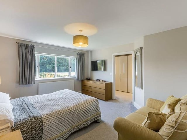 The large and bright master bedroom, which has a carpeted floor, boasts views of the back garden, plus access to a dressing room and an an suite shower room.