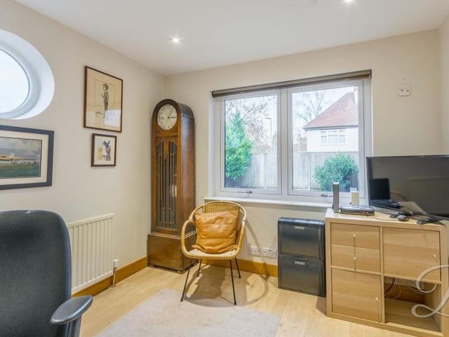 This room is versatile, but it is currently being used as a home office. It has laminate flooring, downlights and dual-aspect windows.