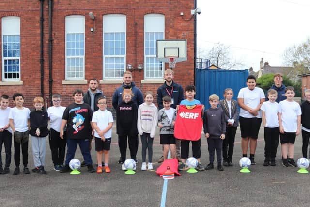 Liam Combellack, of ERF marketing, in the centre with students of The West Park Academy in Kirkby, teachers, Mansfield Town community staff and players.