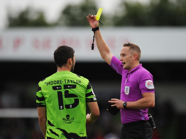 James Bell shows a yellow card to Jordan Moore-Taylor. The leaders have had 47 yellow cards and two double bookings this season.
