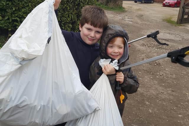 Two young litter-pickers show what they have collected after taking part in the Just Bin It campaign.