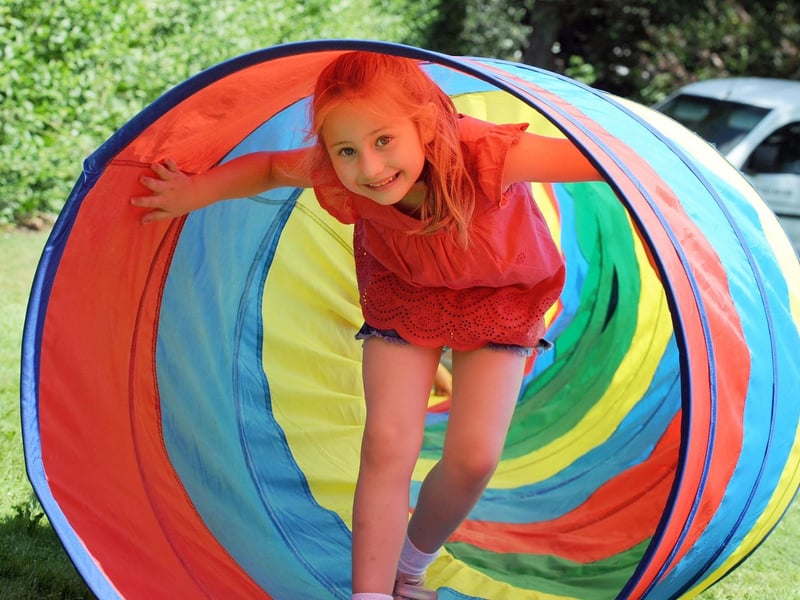 Poppy Scott, 6, emerges from an obstacle course tunnel.