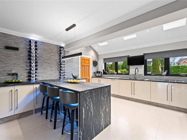 With a range of wall and base units with work surface over, inset sink and drainer with mixer taps over, five burner gas hob with extractor above, integrated wine cooler and dishwasher, electric double oven and grill, feature breakfast bar, two double glazed windows to the front aspect, three velux windows, feature wall tiling and tiled flooring.