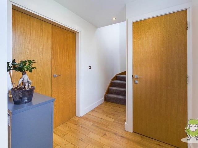 A second shot of the entrance hall, with stairs to the first floor and double doors that lead the way to the main reception area of the house.