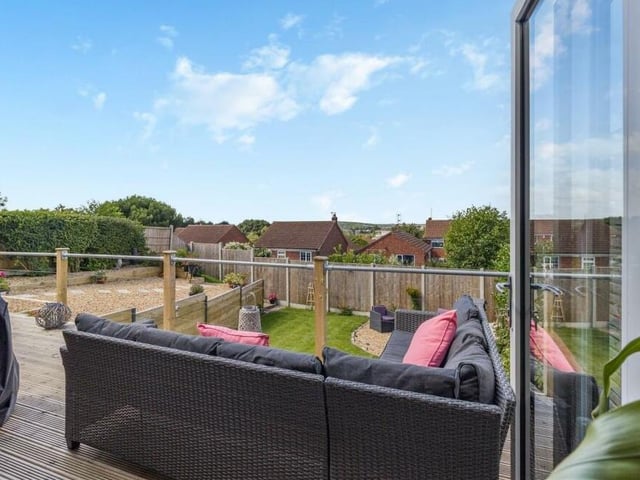 Let's return to the balcony-patio now-- through the bi-fold doors in the open-plan living, dining and kitchen hub and overlooking the landscaped rear garden