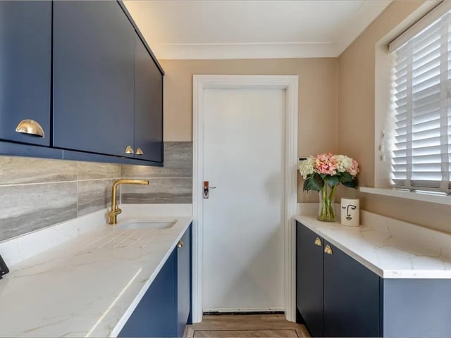 A continuation from the kitchen with matching navy blue shaker cabinets comprising wall and base units complemented by Calacatta quartz worktops. Inset Villeroy & Boch ceramic sink with brass mixer tap. Karndean flooring, coving to ceiling, double glazed window to the rear elevation, double glazed rear door leading out onto the rear garden and personal door through to the double garage.