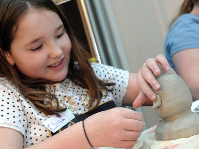 Mud heads challenge Mansfield Museum.     Elissa Loates, 10, starts adding the facial features to her mud head replica in 2017.