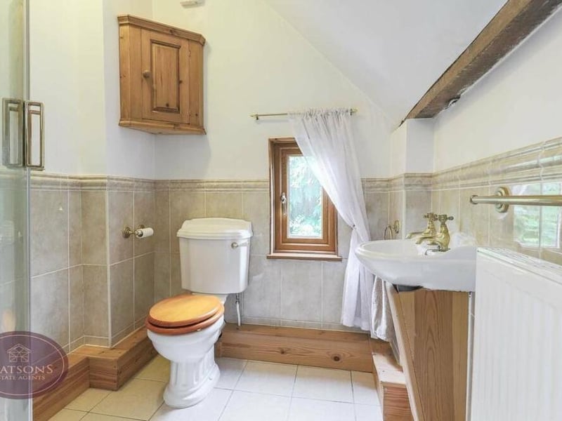This is the second of the en suite shower rooms on the first floor. A three-piece suite consists of a shower cubicle with electric shower, wall-mounted sink and WC