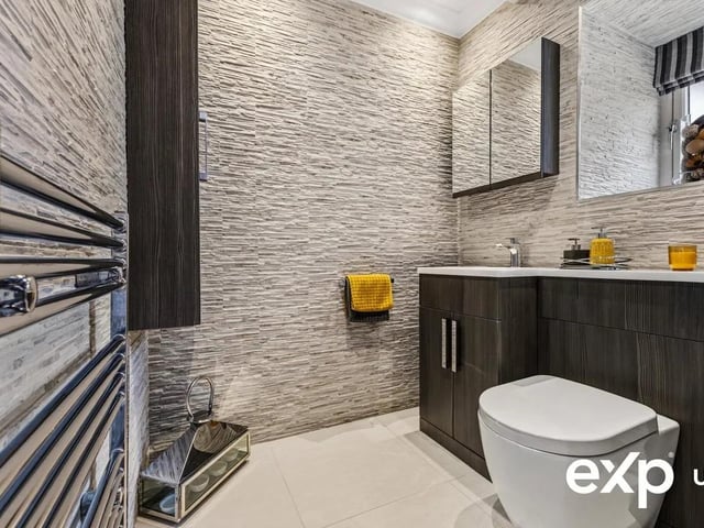 Conveniently located off the entrance hall, the spacious modern cloakroom is decorated with tiled walls and tiled flooring