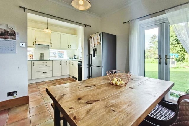 Attached to the kitchen is a lovely living area, with space for a fridge freezer and a breakfast or dining table. Doors lead out to the garden.