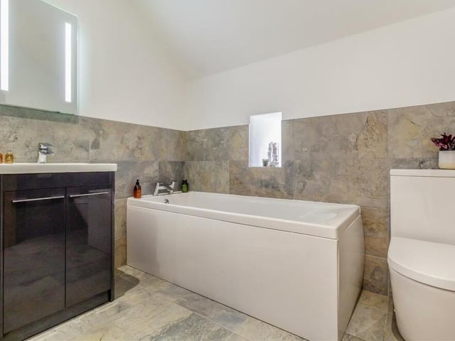The last bit of the first floor to look at is the family bathroom, which comprises a modern four-piece suite with chrome fittings. There is a bathtub with mixer tap, a separate double-width and tiled shower enclosure with rainfall shower, vanity unit with inset wash hand basin and storage cupboard beneath, and a low-flush WC. Not to mention a fitted mirror and chrome, heated towel-rail.