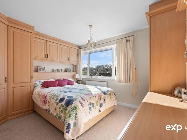 A charming double bedroom decorated with elegant touches. There is a vast range of fitted wardrobes offering plenty of storage and incorporating a dressing table. A walk in storage cupboard offers further practicality. There is a radiator, and a uPVC window to the front.