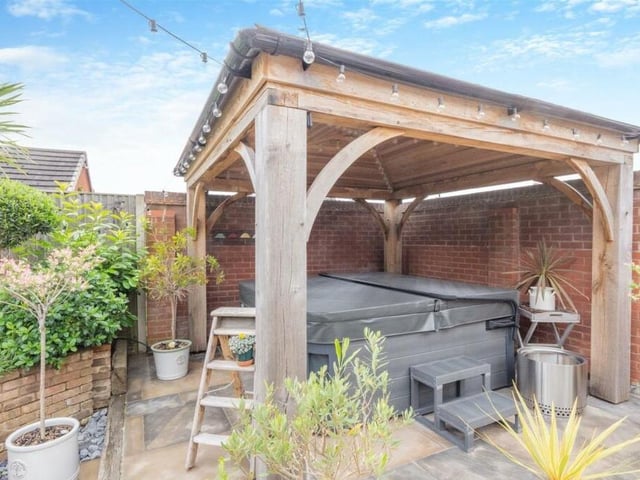 This garden just keeps on giving. Here is a large, green oak gazebo,with cedar shingle roof and space beneath for a hot tub, all enclosed by a wall boundary.