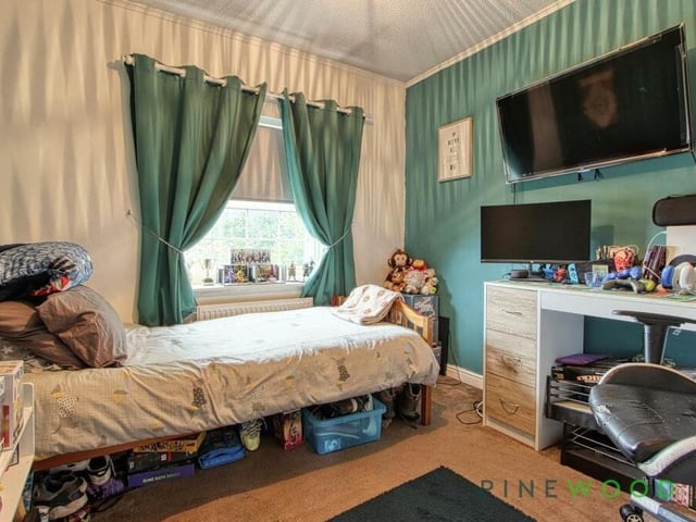 Bedroom number two, which overlooks the back garden, is a busy but bonny space. Assets include a walk-in double wardrobe and a fitted carpet.