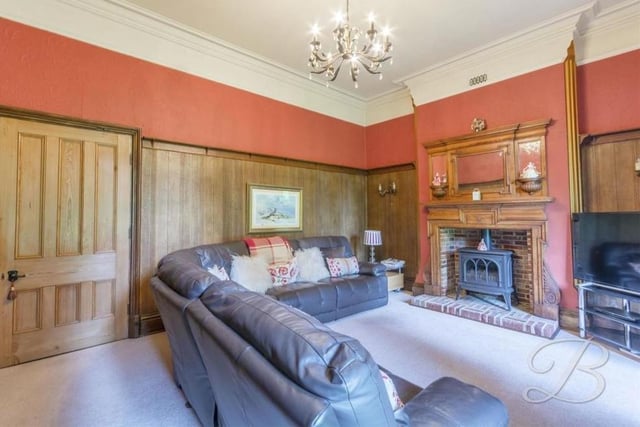 The first ground-floor reception room to inspect is this luxurious lounge, with its feature fireplace and gas stove. Wooden panelling gives the room an air of authority.