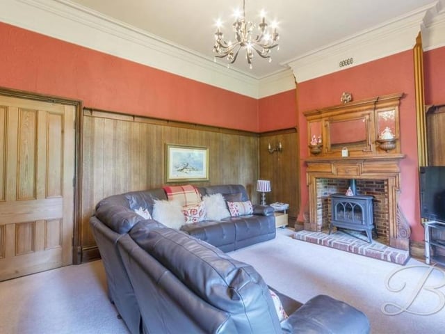 The first ground-floor reception room to inspect is this luxurious lounge, with its feature fireplace and gas stove. Wooden panelling gives the room an air of authority.