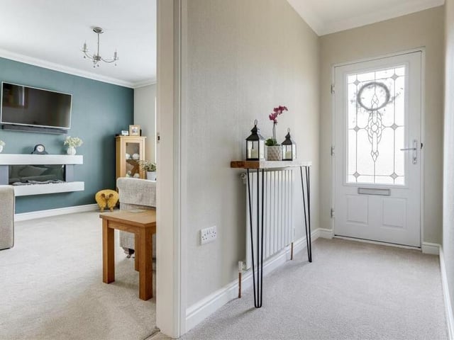As we step inside the £260,000 Kirkby bungalow, we are greeted by this welcoming entrance hall, which has a carpeted floor, coving to the ceiling and a built-in double-door cupboard. As you can see, it also leads conveniently into the living room.