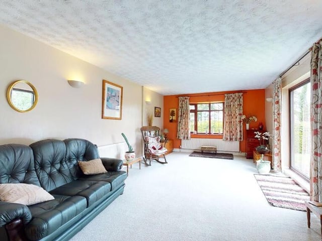 Next to the lounge is this large sitting room or family room. The bay window offers delightful, far-reaching views of the garden and open fields that adjoin the bungalow.