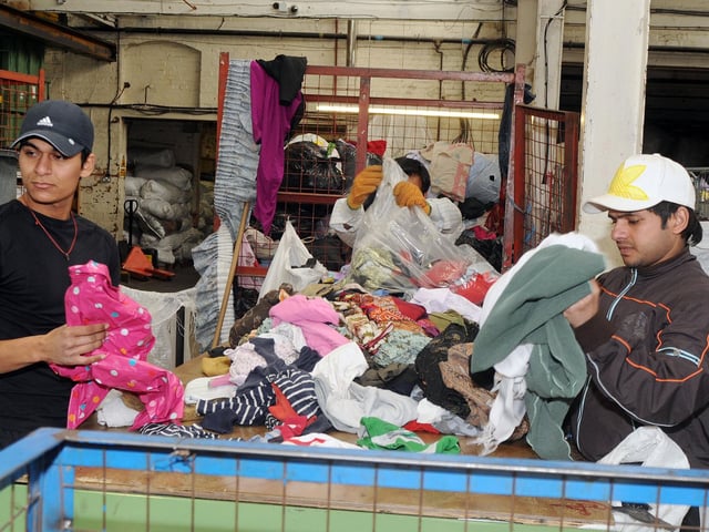 Workers sort textiles into various grades and prepare them for export.