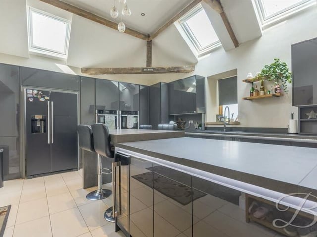 The striking kitchen features a show-stopping island, with breakfast bar, wine cooler and ample storage.