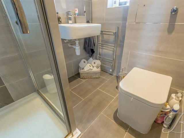 Here is the en suite shower room to the master bedroom. It is a three-piece suite featuring shower cubicle, wash hand basin and WC.
