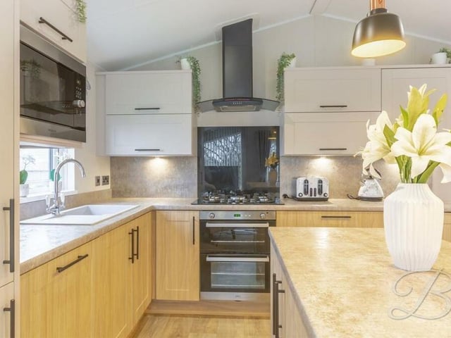 An essential array of integrated appliances make the modern kitchen well worthy of the flowers that adorn the breakfast bar.