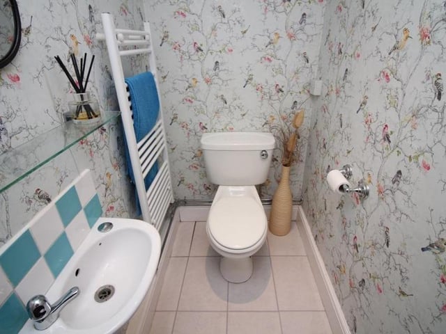 The colourful downstairs toilet at the Nottingham Road property has a WC, wall-mounted sink, heated towel-rail and ceiling spotlights.
