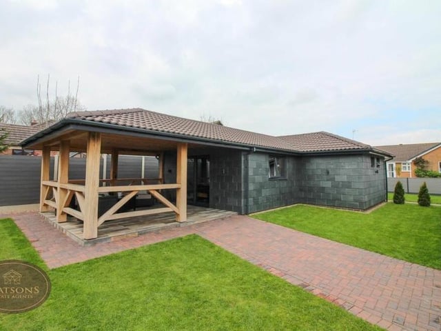 Let's step outside now and take a look at the self-contained annexe, which is undoubtedly one of the property's prized assets. It is rendered with natural slate and completed to a superior standard.