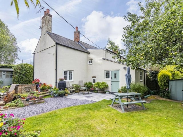 Time to step outside now to discover a beautifully presented, cottage-style garden.There are lawns, pathways, numerous seating areas and an outbuilding. This shot also shows the feature entrance stable-door to the property.