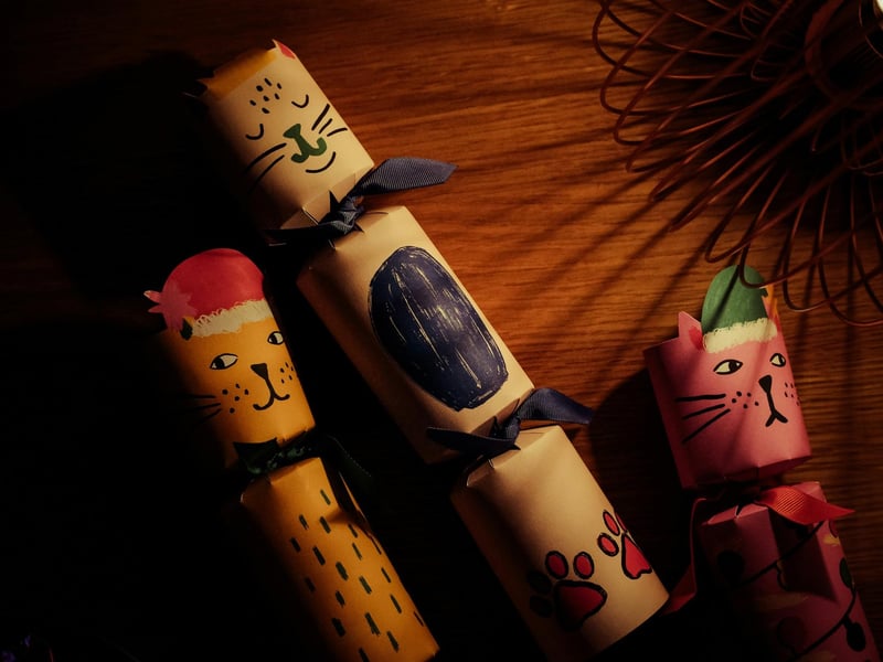 Hand-made Christmas Crackers: These are a classic festive fun craft, allowing for personalized designs and gifts. All you need is cardboard toilet-paper tubes (one per cracker), cracker snaps (optional), these provide the "bang" and can be purchased online or from craft suppliers, ensure they are appropriate for the size of your tube. Wrapping paper or crepe paper (approx. 12 x 8 inches per cracker), scissors, double-sided tape or a glue stick and ribbon or twine. To assemble, insert a cracker snap into the cardboard tube, fill the cracker with your your chosen fillers inside the tube. Wrap the tube in either wrapping paper or crepe paper by placing the filled tube along one edge and wrap it around, securing the seam with glue or double-sided tape. Ensure the paper extends past both ends of the tube by a few inches. Tightly tie a ribbon around the paper at both ends of the tube, creating the classic gathered cracker shape. Trim and decorate.