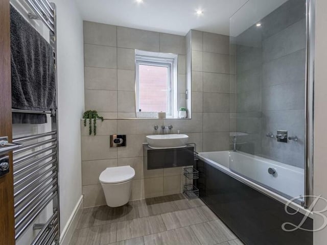 The first floor is completed by this contemporary family bathroom. A three-piece suite includes a bath with overhead shower, a hand wash basin and a low-flush WC.
