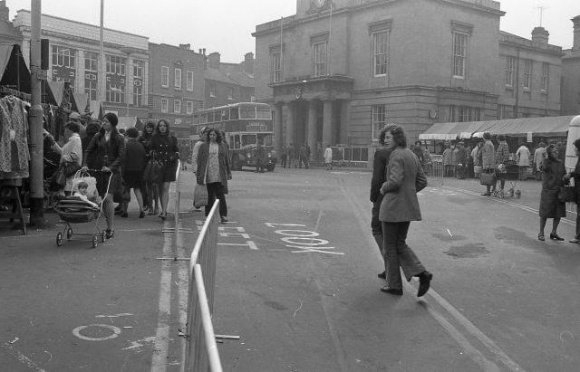 Can you spot any familiar faces enjoying the market many years ago?