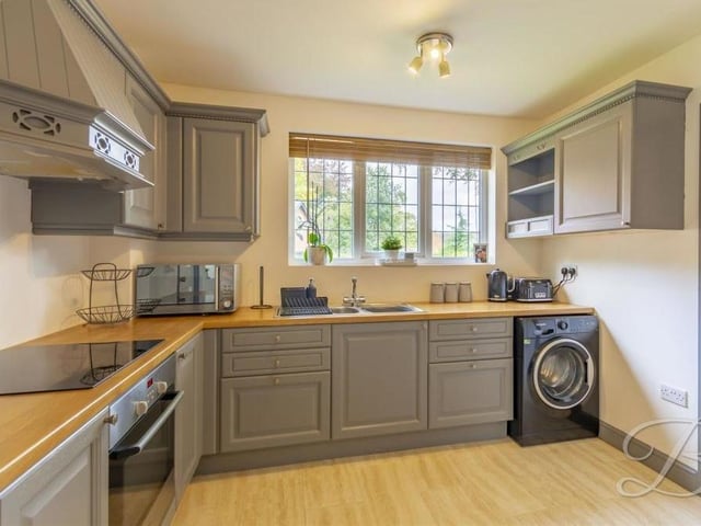 The kitchen in the annexe is a neat and stylish space, fitted with shaker-style cabinets and units. There is also a work surface, extractor fan, ceramic hob and stainless steel inset sink and drainer with a chrome mixer tap above, plus plumbing for a washing machine.