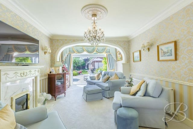 The ground floor of the Kirkby property is dominated by this beautiful open-plan lounge that creates a warm and welcoming atmosphere. It includes a traditional feature fireplace, a carpeted floor and sliding doors leading out to the garden.