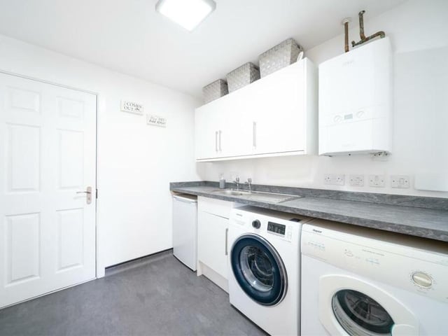 One more downstairs room to show you, and that's this useful utility room, which has been created in part of the property's integral garage as part of the restyling project. As you can see, there are units, a worktop, sink and space for a washing machine and tumble dryer.