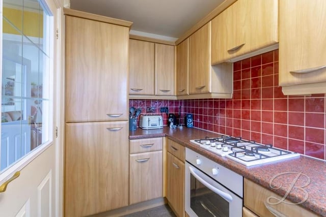 Our second photo of the kitchen shows that its integrated appliances include a fridge freezer. A window overlooks the front of the property, while the pictured door leads back into the entrance hallway.