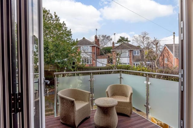 Here is that balcony, which provides a terrific outdoor seating area. It has a decked floor, contemporary balustrade with brushed metal hand-rail above, and steps leading down to the back garden.