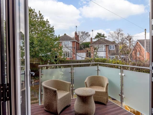 Here is that balcony, which provides a terrific outdoor seating area. It has a decked floor, contemporary balustrade with brushed metal hand-rail above, and steps leading down to the back garden.