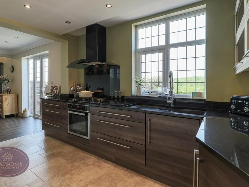 The kitchen offers functionality and style. A range of matching wall and base units is offset by granite work surfaces that incorporate an inset quartz sink bowl with flexi-tap and drainer.