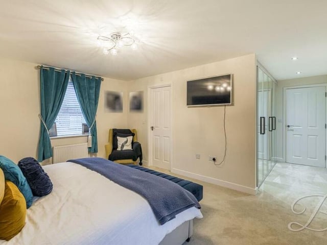 This second photo of the main bedroom shows how it includes large fitted wardrobes.