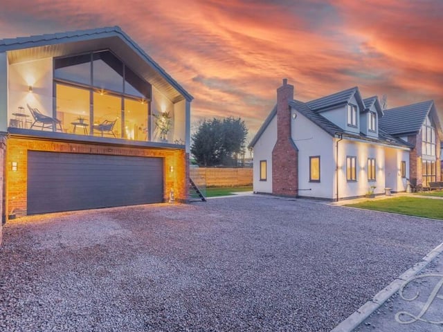 Let's switch our attention now to the second-storey extension to the large, detached double garage, which has ample space for two cars, extra room for storage and off-street parking space in front of it. An external staircase leads to the extension above.