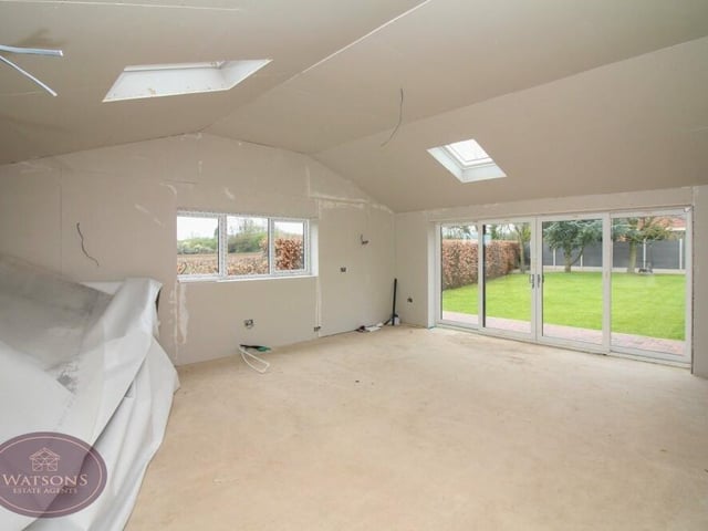 The open-plan dining kitchen also incorporates a family room, with uPVC double-glazed sliding doors to the rear garden.