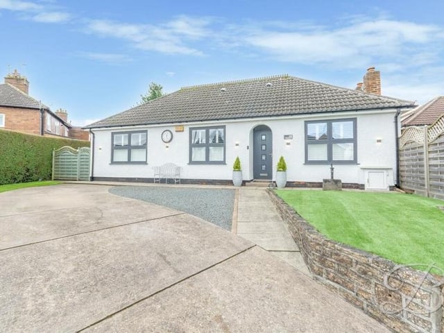 Returning to the front of the £375,000-plus Kirkby bungalow, where a lengthy driveway provides ample off-street parking space.