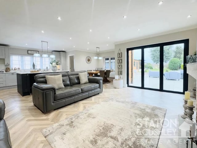 The open plan living space features an abundance of natural light streaming in from the patio doors.