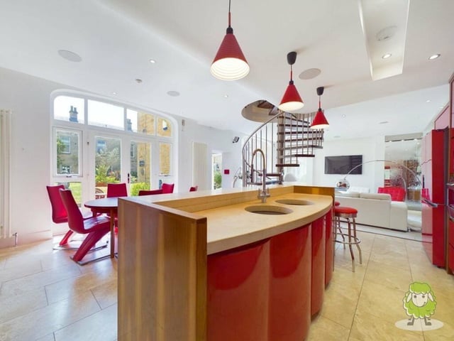 The kitchen offers plenty of space, with room for a dining table close by and views of the outside courtyard from large windows.