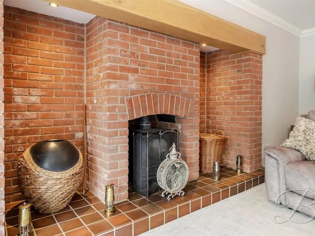 A striking exposed brick feature fireplace is a stunning focal point of the living room.