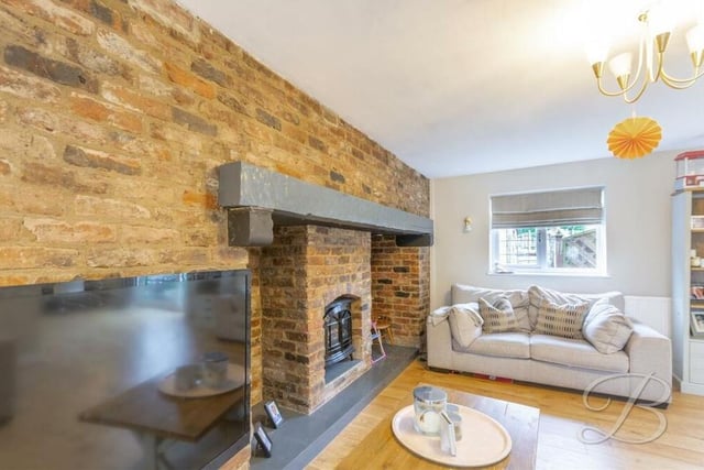 A feature fireplace with open-brick surround is one of the highlights of the living room.